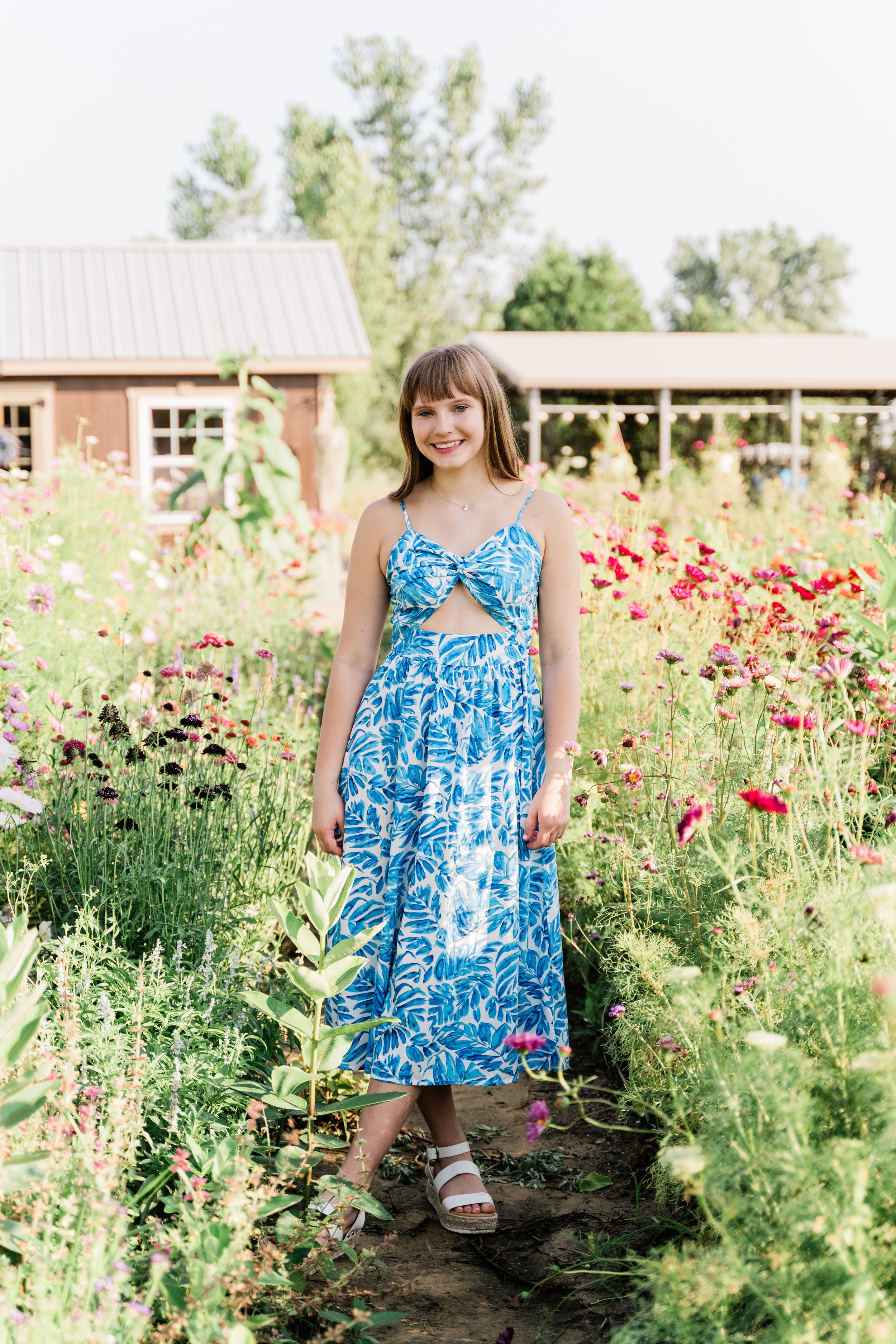 A series of garden portraits showing someone in a blue floral dress sitting among blooming red wildflowers and greenery.