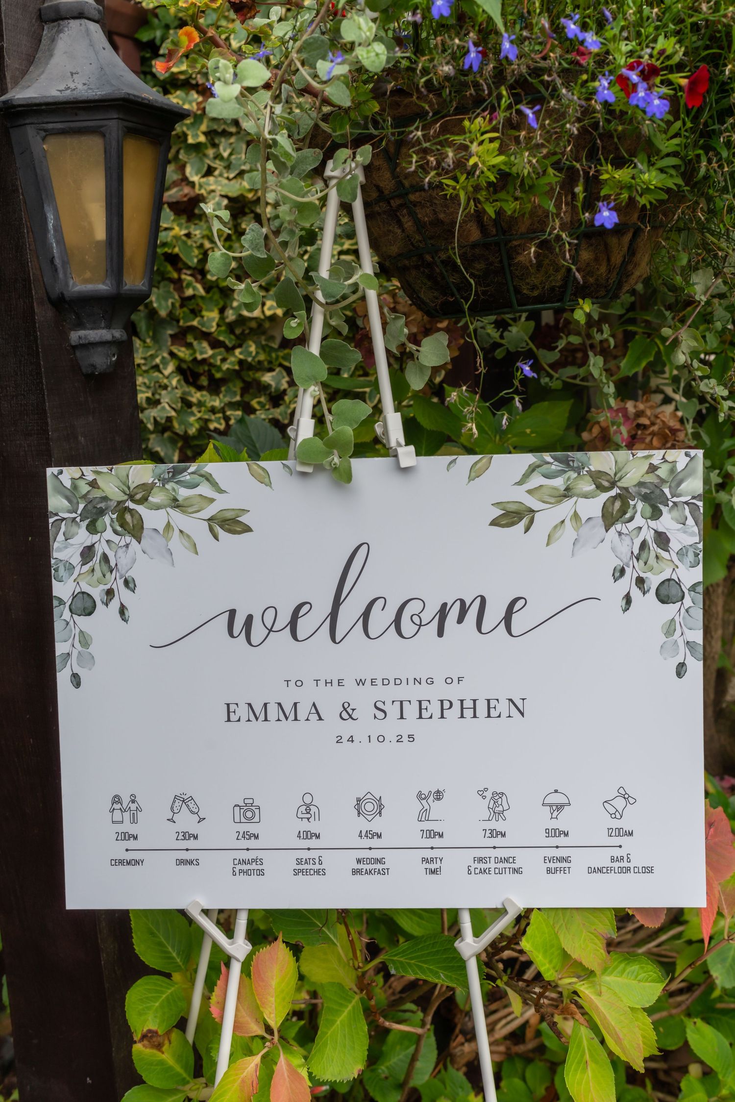 Rustic wedding welcome sign with timeline icons and lantern decor at The Plough Inn, Eaton; detailed wedding photography by Michael Pardoe.