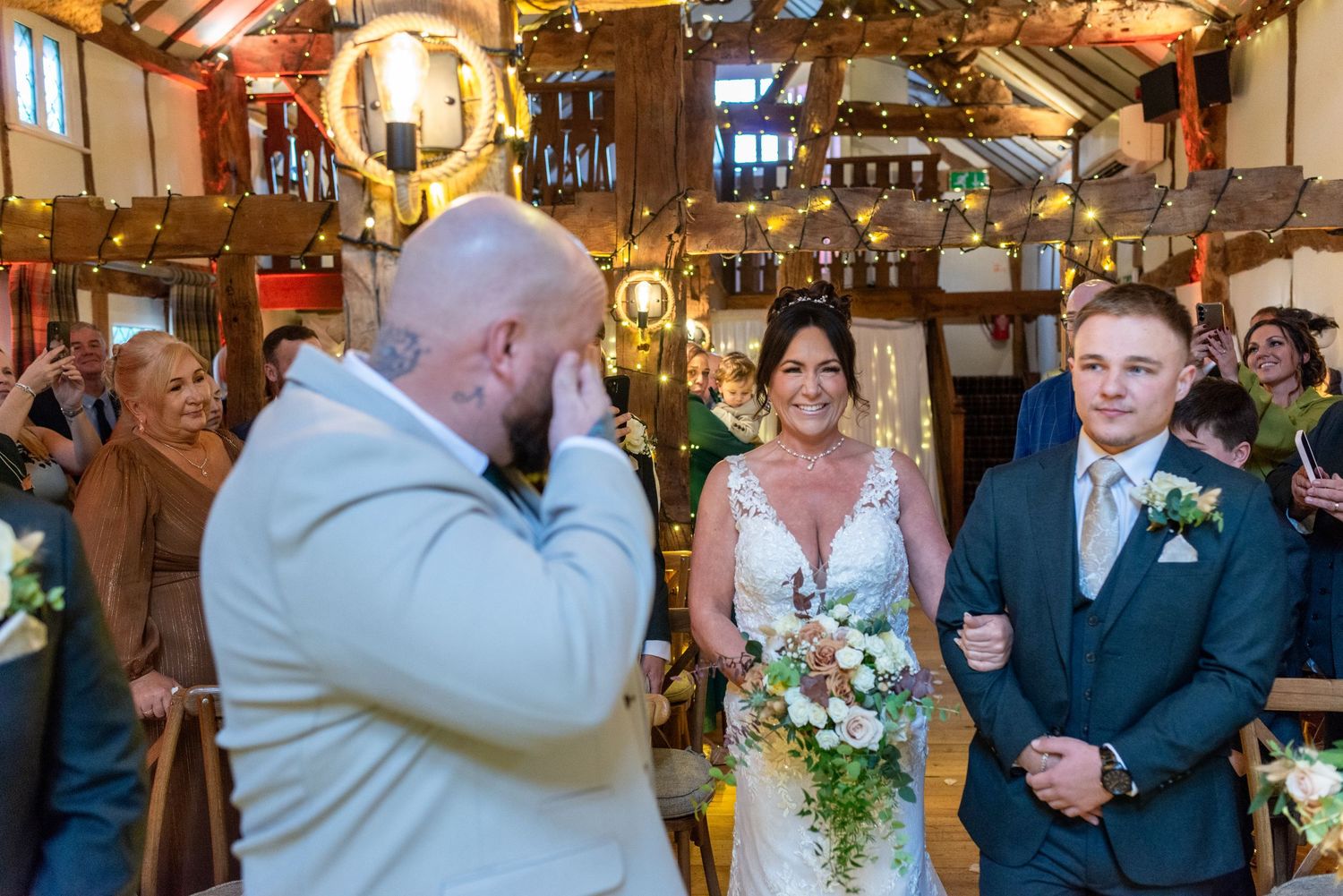 Emotional groom reaction as bride walks down the aisle at The Plough Inn, Eaton; candid barn ceremony photography by Michael Pardoe.
