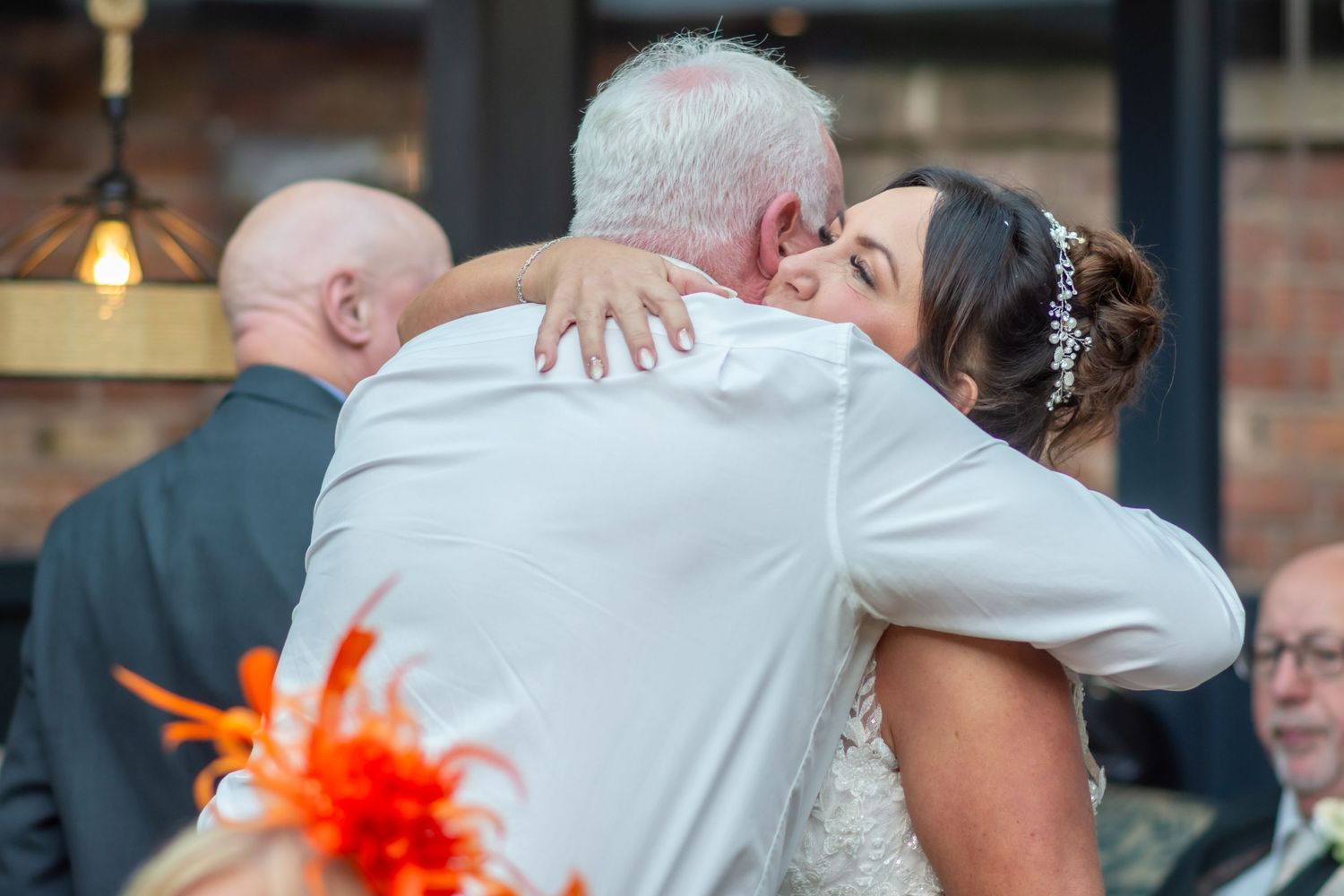 A series of candid wedding photos showing joyful embraces and celebrations between guests at a reception.