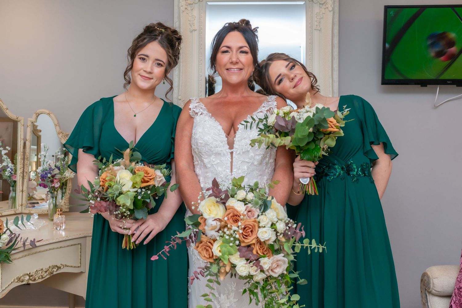 Bridesmaids in emerald green dresses with colourful autumn bouquets at The Plough Inn, Eaton; wedding photography by Michael Pardoe