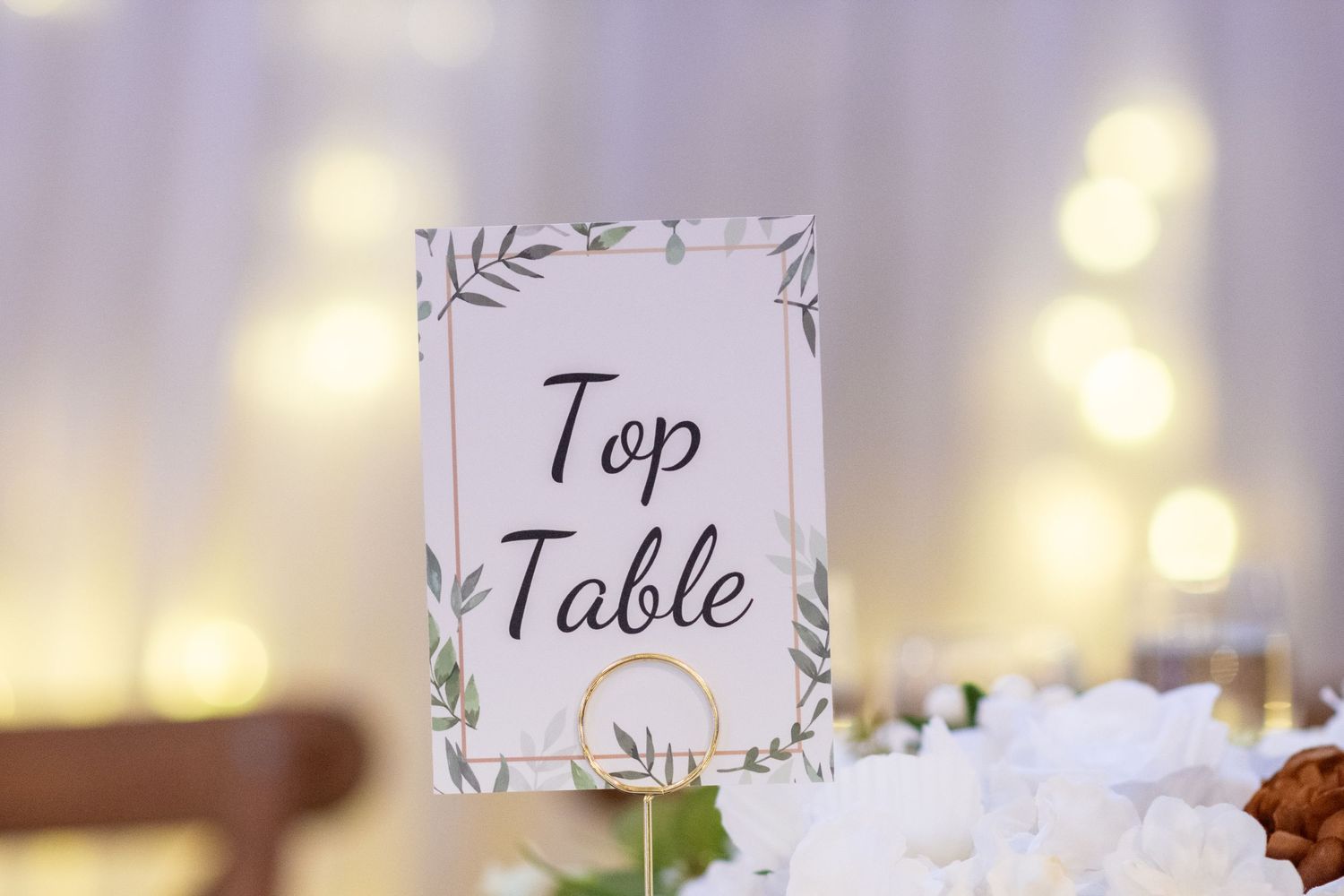 Elegant wedding reception table settings with floral decorations and name cards.