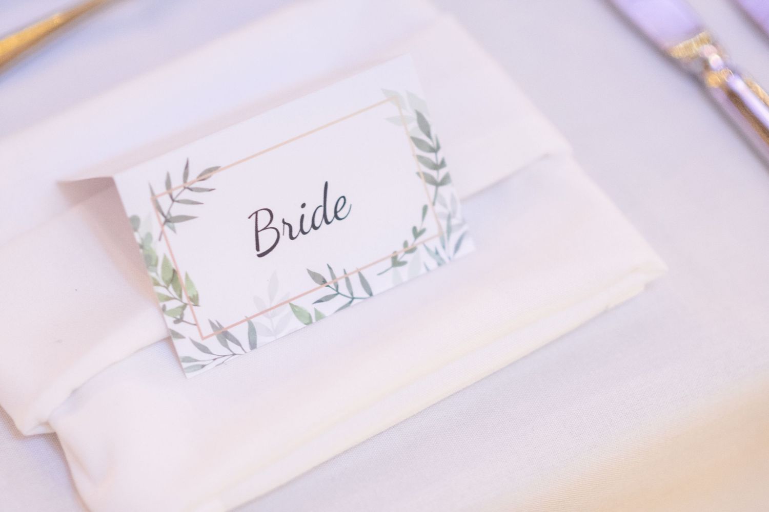 Elegant wedding place cards with delicate leaf designs in soft purple tones.