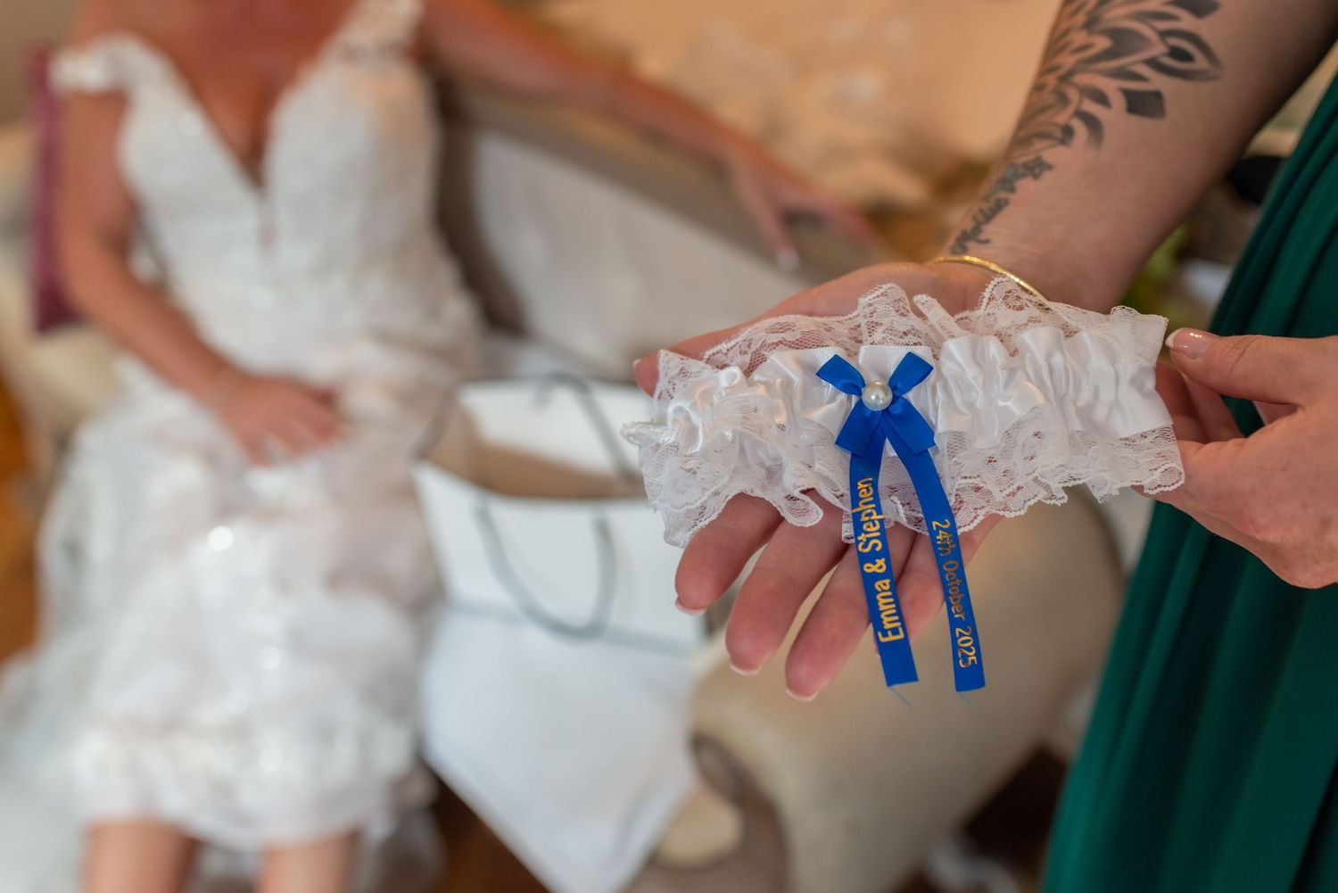 Delicate lace bridal garter with a 'something blue' ribbon bow; artistic wedding detail photography in Cheshire by Michael Pardoe.
