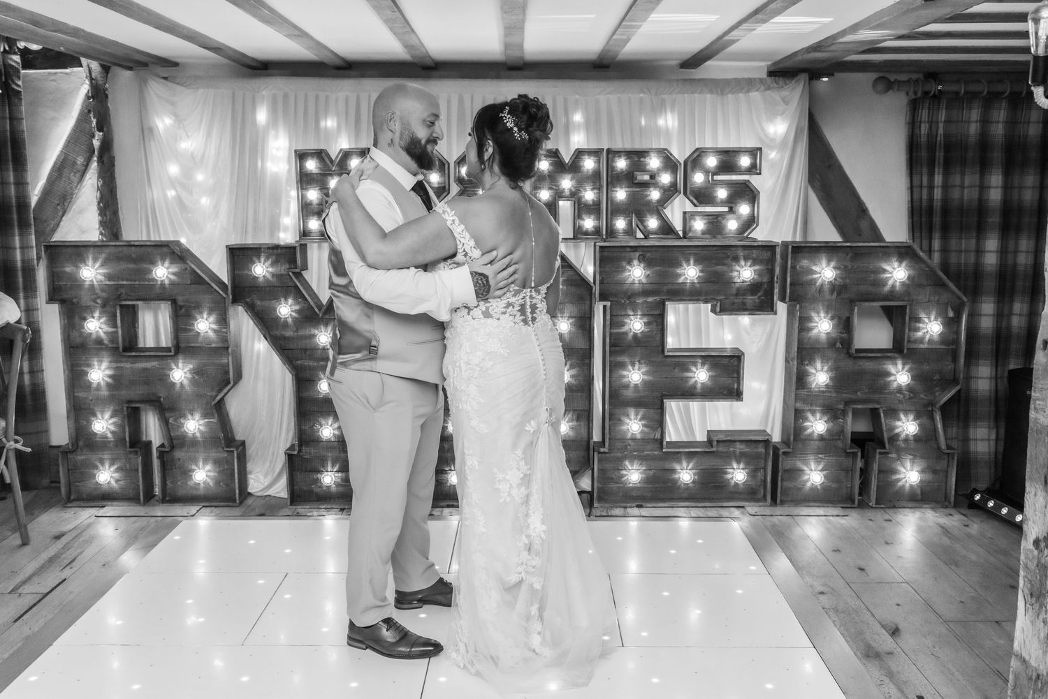 Wedding reception dance floor with illuminated LOVE letters in the background.