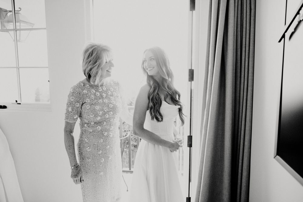 Wedding party members standing together in a bright indoor space.
