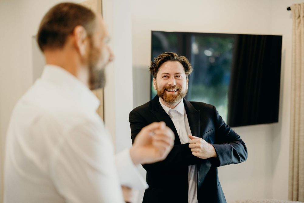 Groomsmen in formal attire socializing before the wedding ceremony.