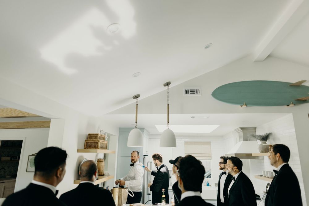 Wedding party toasting with drinks in a modern indoor space.