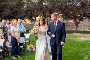 A group of wedding guests gathered on a lush green lawn during an outdoor celebration.
