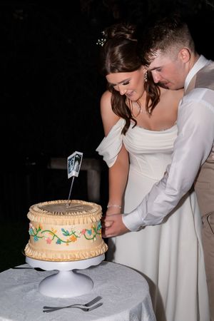 A wedding cake cutting sequence shows the traditional moment of a couple slicing into their decorated white cake together.
