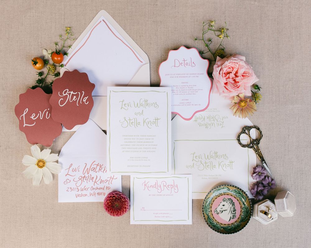 Elegant wedding invitation suite with pink and burgundy stationery, floral accents, and vintage styling on linen background.