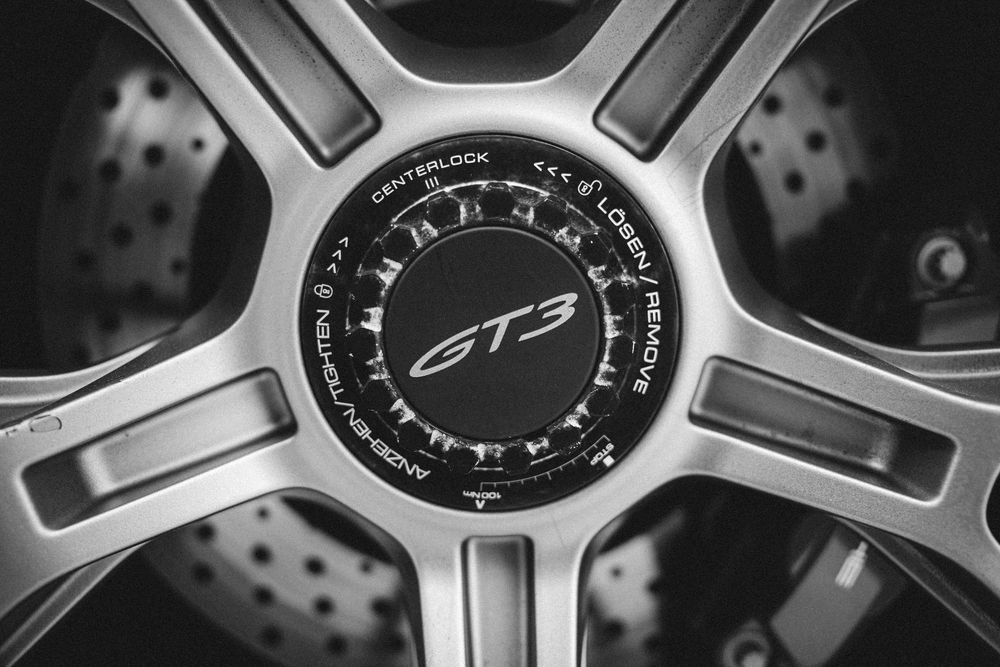 Close-up montage of luxury car wheel rims showing detailed silver spokes and performance brake rotors.