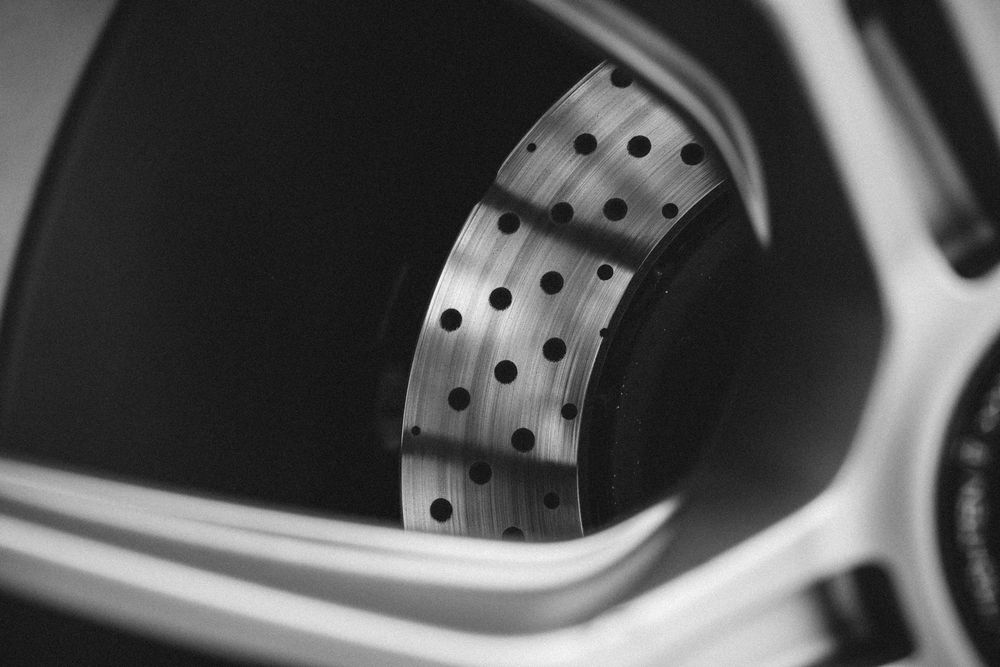 Detail shot of performance brake rotors with drilled holes on a luxury sports car.