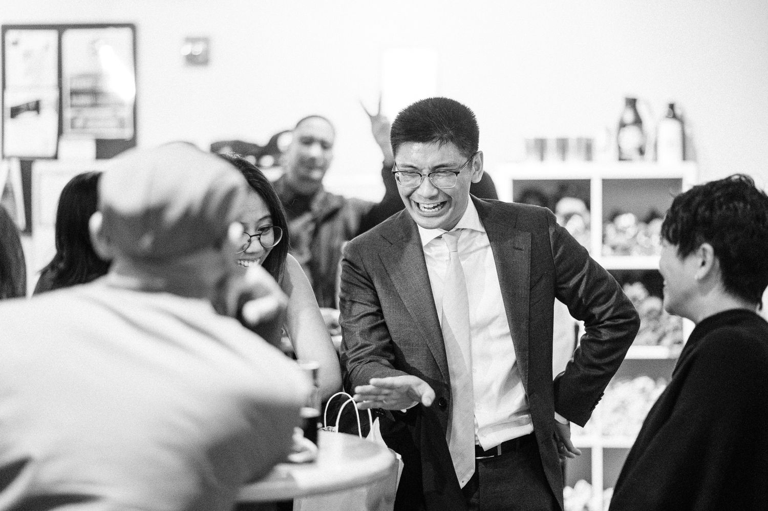 groom engages in animated conversations at a crowded brewery during wedding