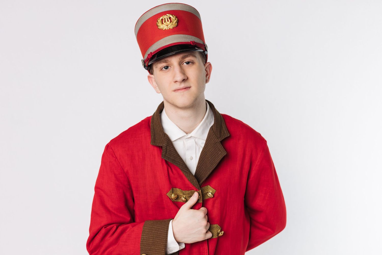 A person wearing a red uniform jacket and cap poses in different positions against a white background.