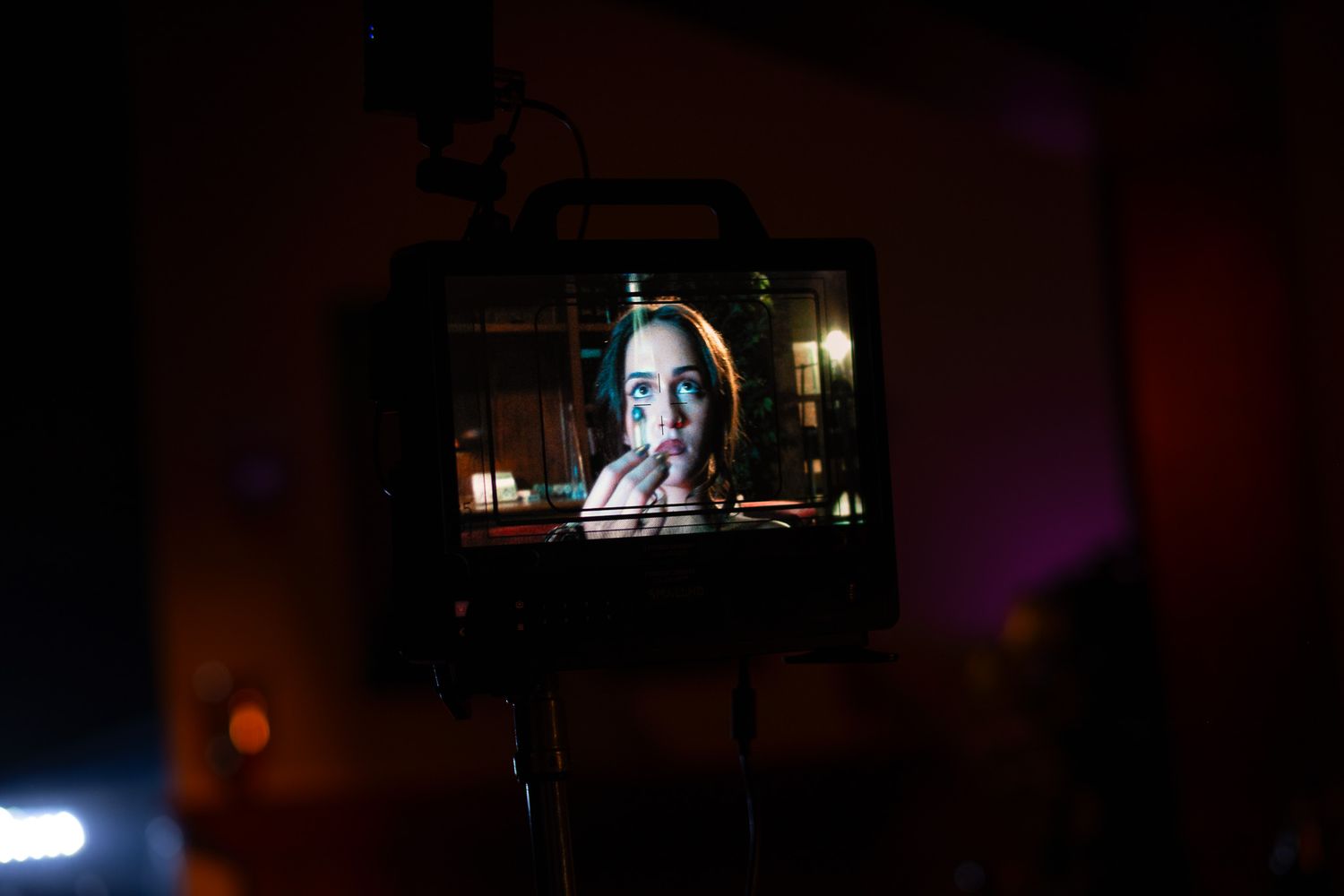 Dark room illuminated by production lighting equipment creating atmospheric shadows.