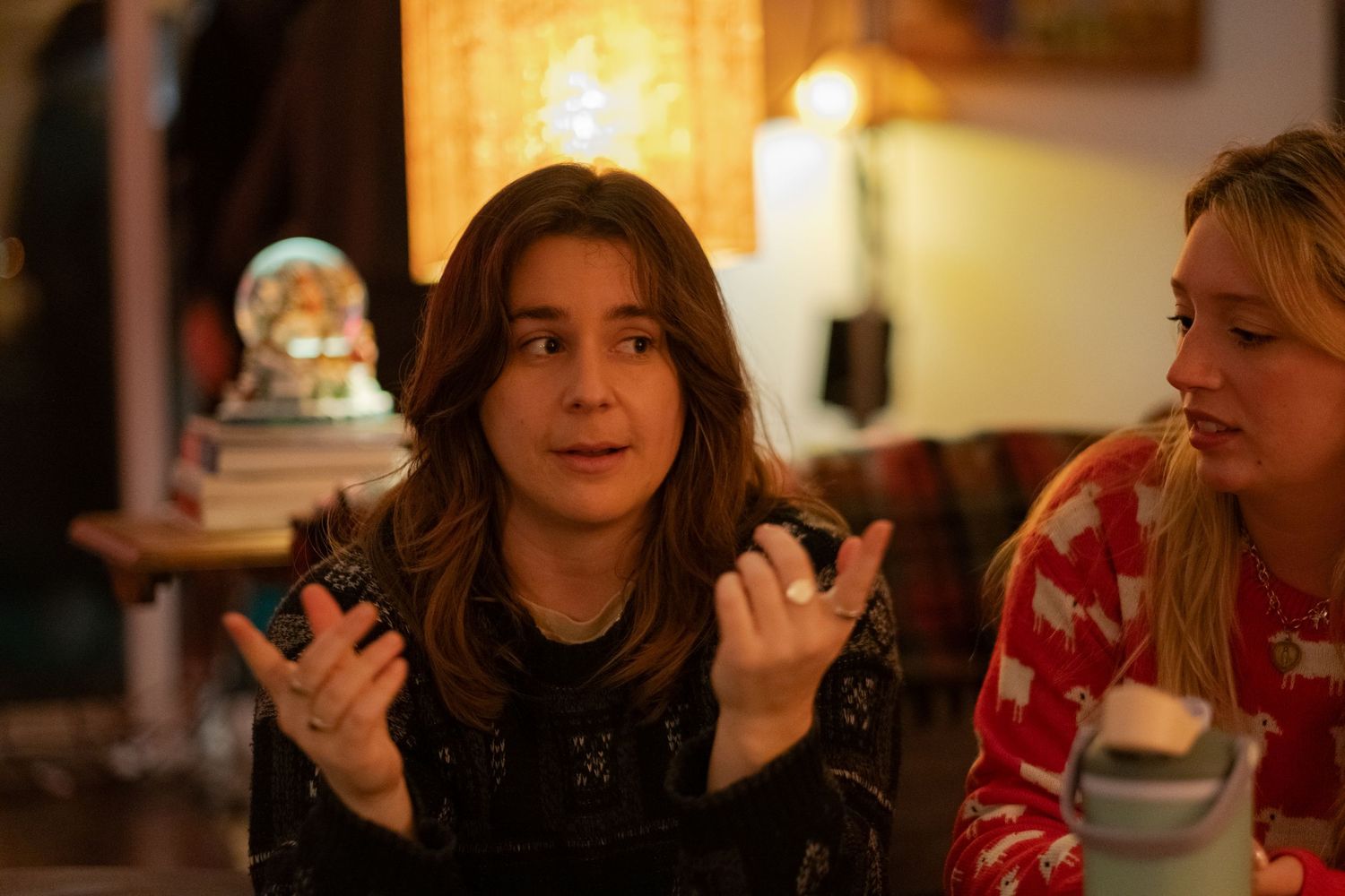 A group of people enjoying coffee and conversation in a cozy cafe setting with warm lighting.
