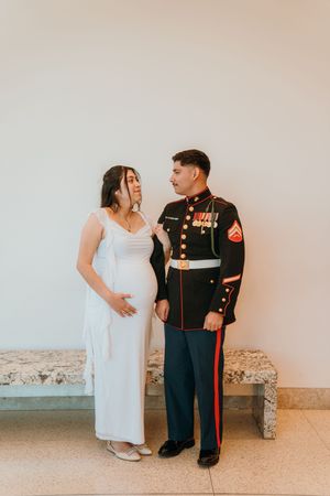 A couple shares candid moments in a photo series showing a person in white dress and another in military dress uniform.