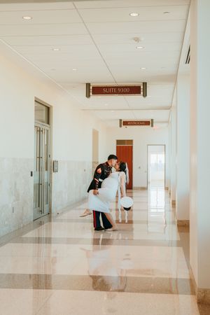 A long, bright hallway in a modern office building with polished floors and recessed lighting reflects off white walls.