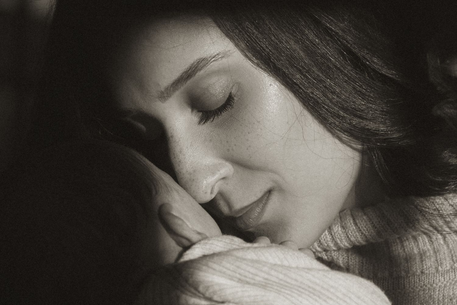 A black and white portrait of someone sleeping peacefully with eyes closed and a gentle smile.