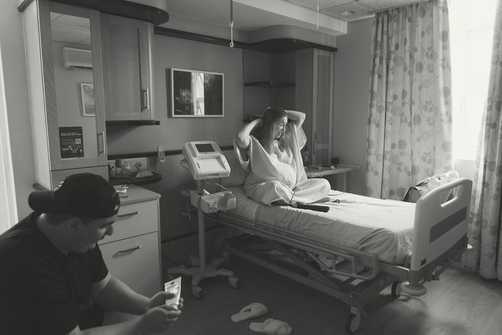A hospital patient lies in a medical bed while receiving care in a clinical setting.