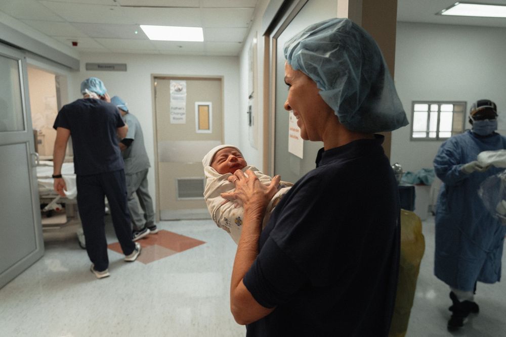 A series of connected images showing medical staff in protective gear walking through a hospital corridor.