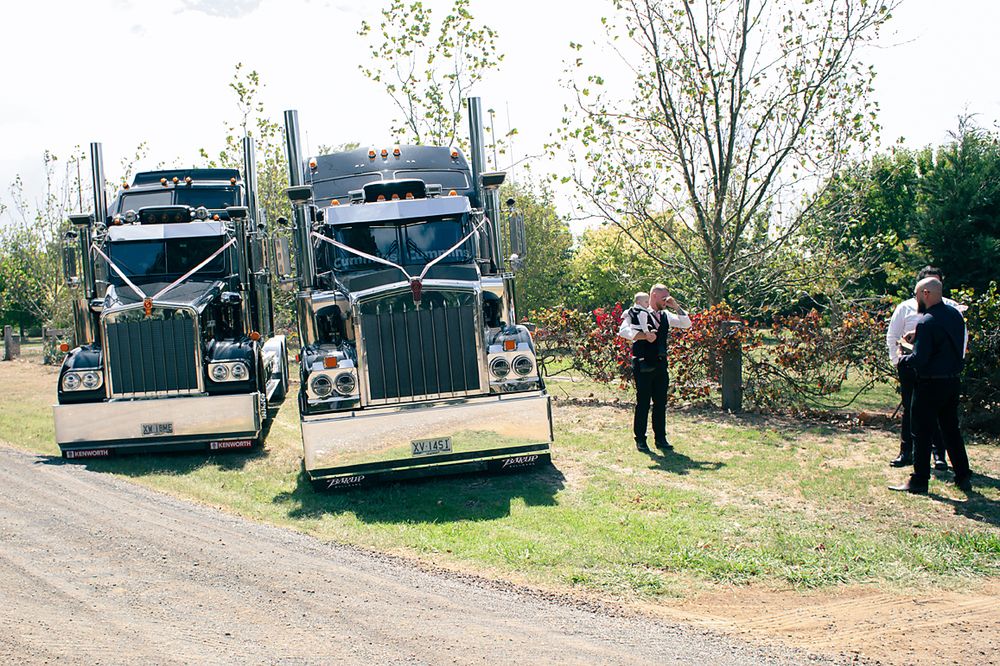 Police vehicles and officers gather on a rural dirt road during an outdoor investigation scene.
