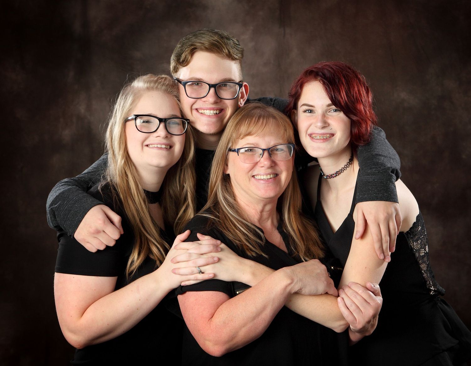 A series of black and white studio portraits showing three people posing together against a dark background.