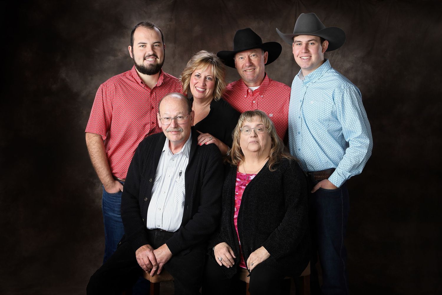 A group of people pose together in a series of connected portrait photographs against a dark background.