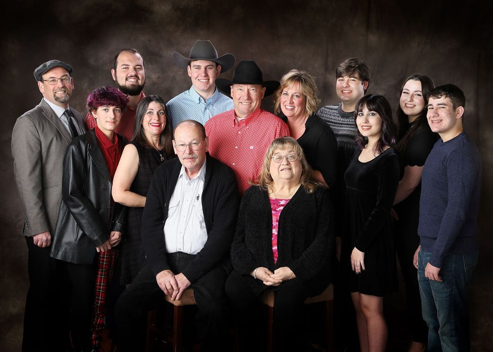 A series of professional dark studio portraits showing groups of people posing together against black backgrounds.