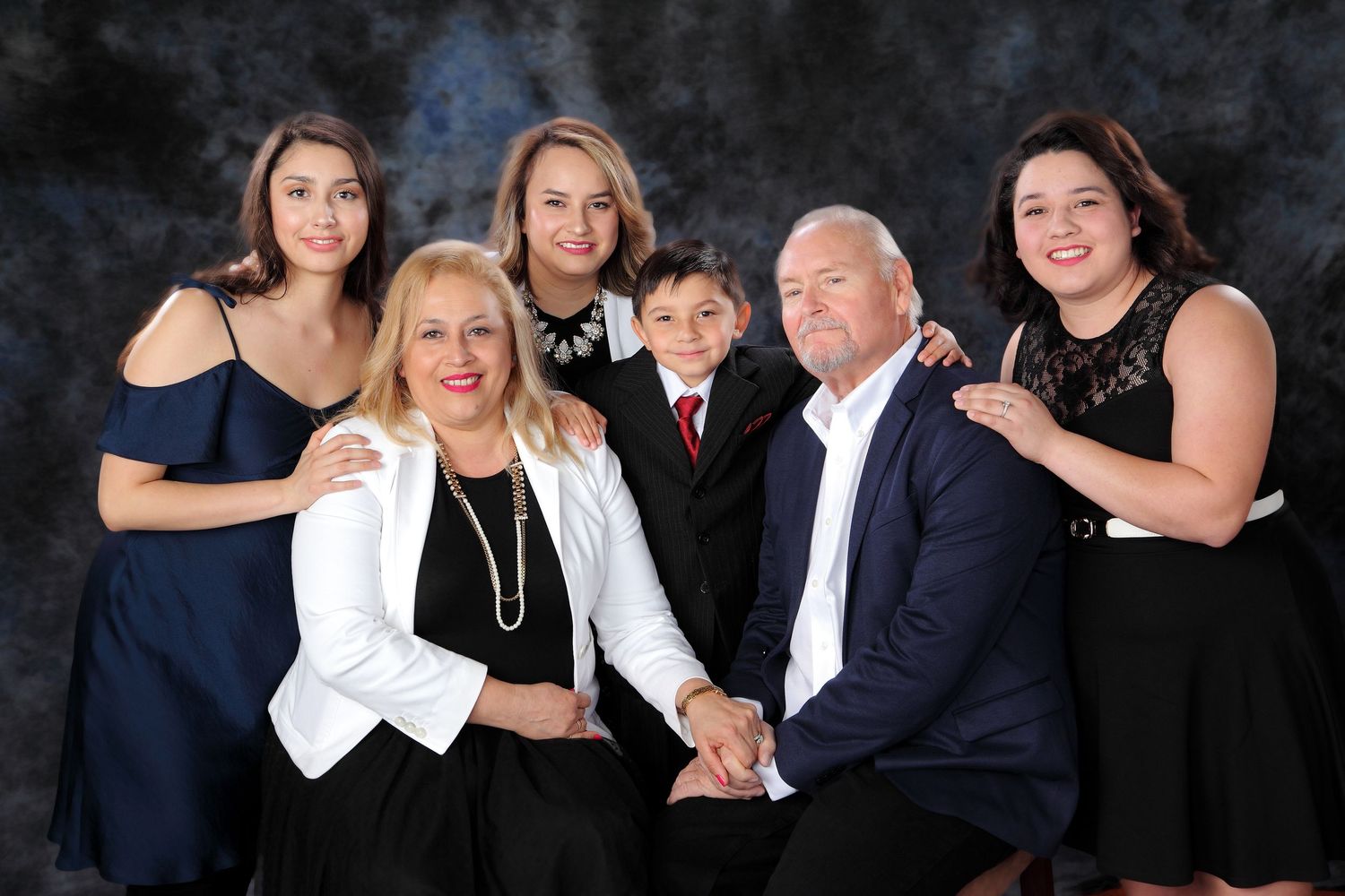 A collage of candid family photo moments showing laughter and joy during a professional portrait session in dark attire.