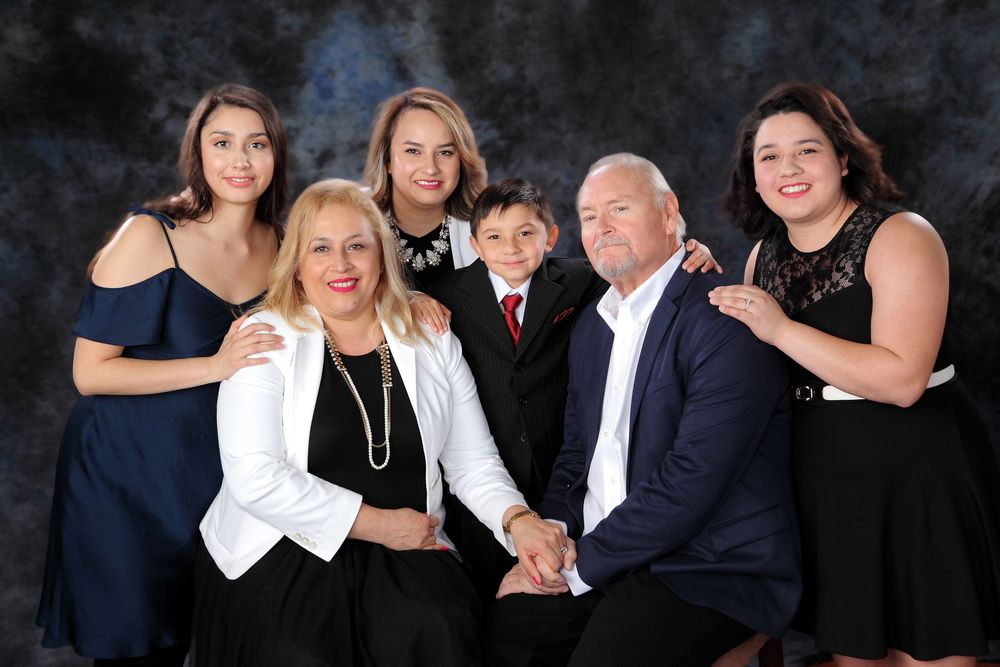 A collage of candid family photo moments showing laughter and joy during a professional portrait session in dark attire.