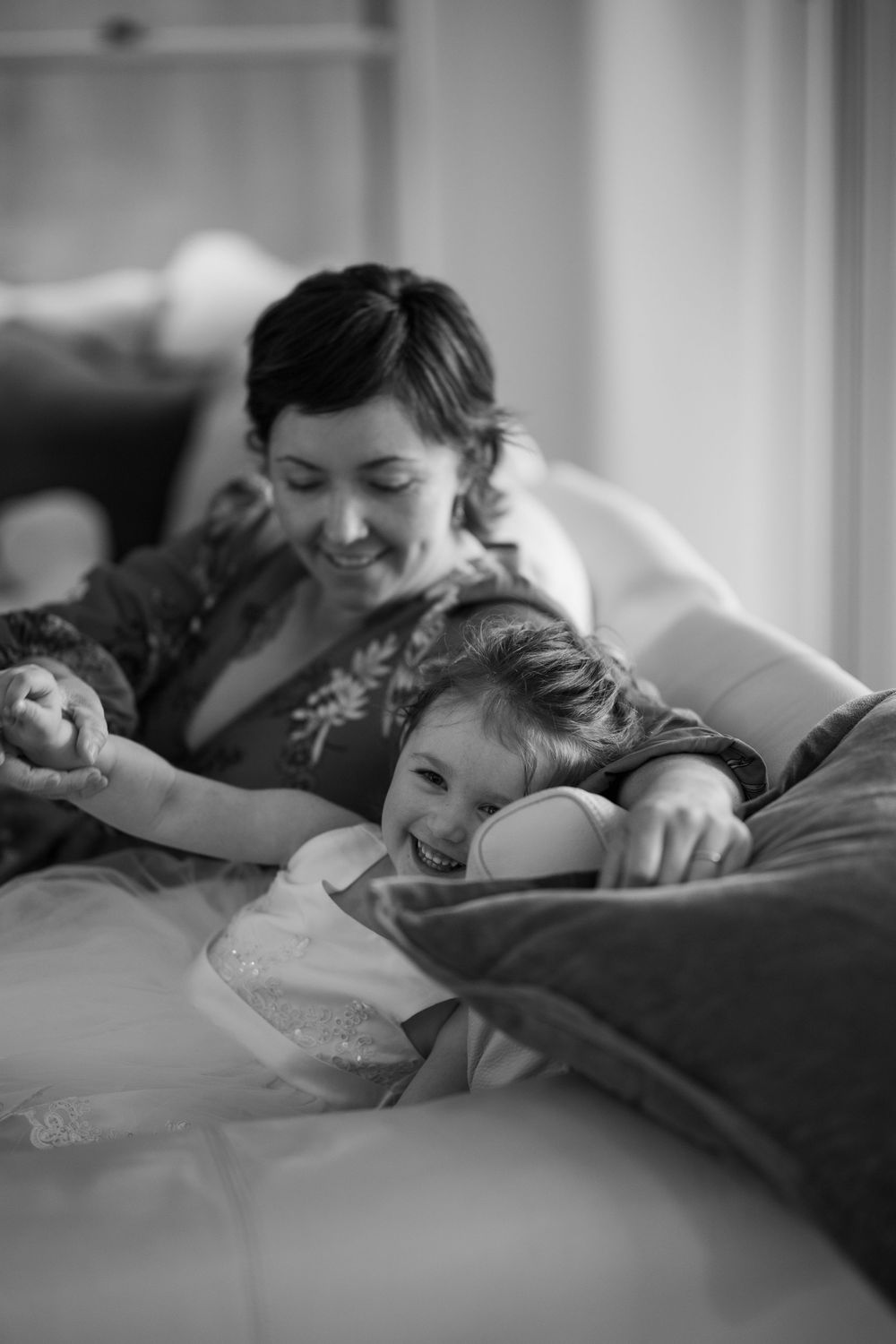An intimate black and white sequence of tender moments shared on a bed.