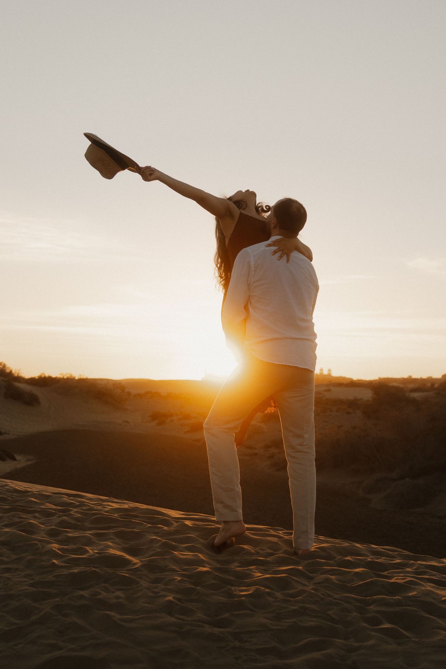 Intimate pre-wedding session with a couple slow dancing under a warm golden sunset.