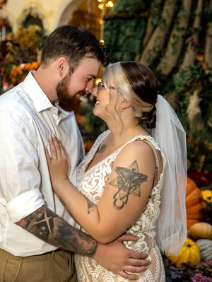 A romantic wedding moment captured in a garden setting with warm lighting and autumn decorations.