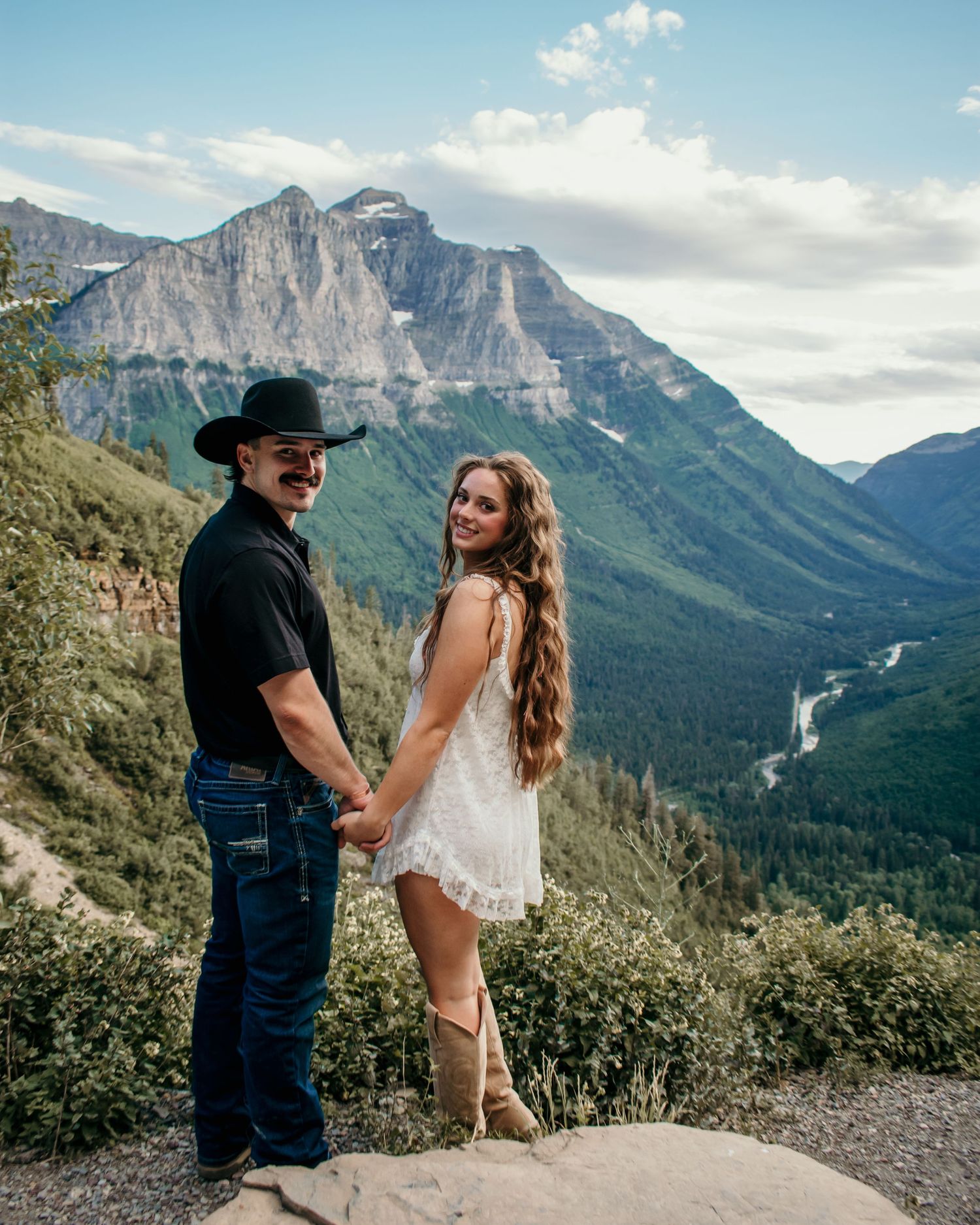 Panoramic sequence of a couple in white outfits walking through a scenic mountain landscape on a sunny day.