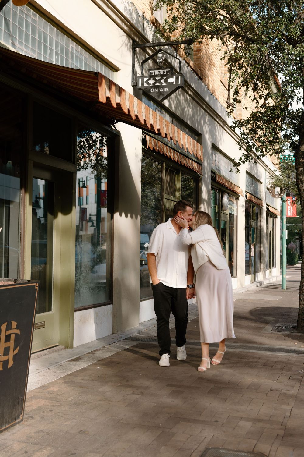 A sequence of five photos showing a couple dancing together on a city sidewalk in front of storefronts.