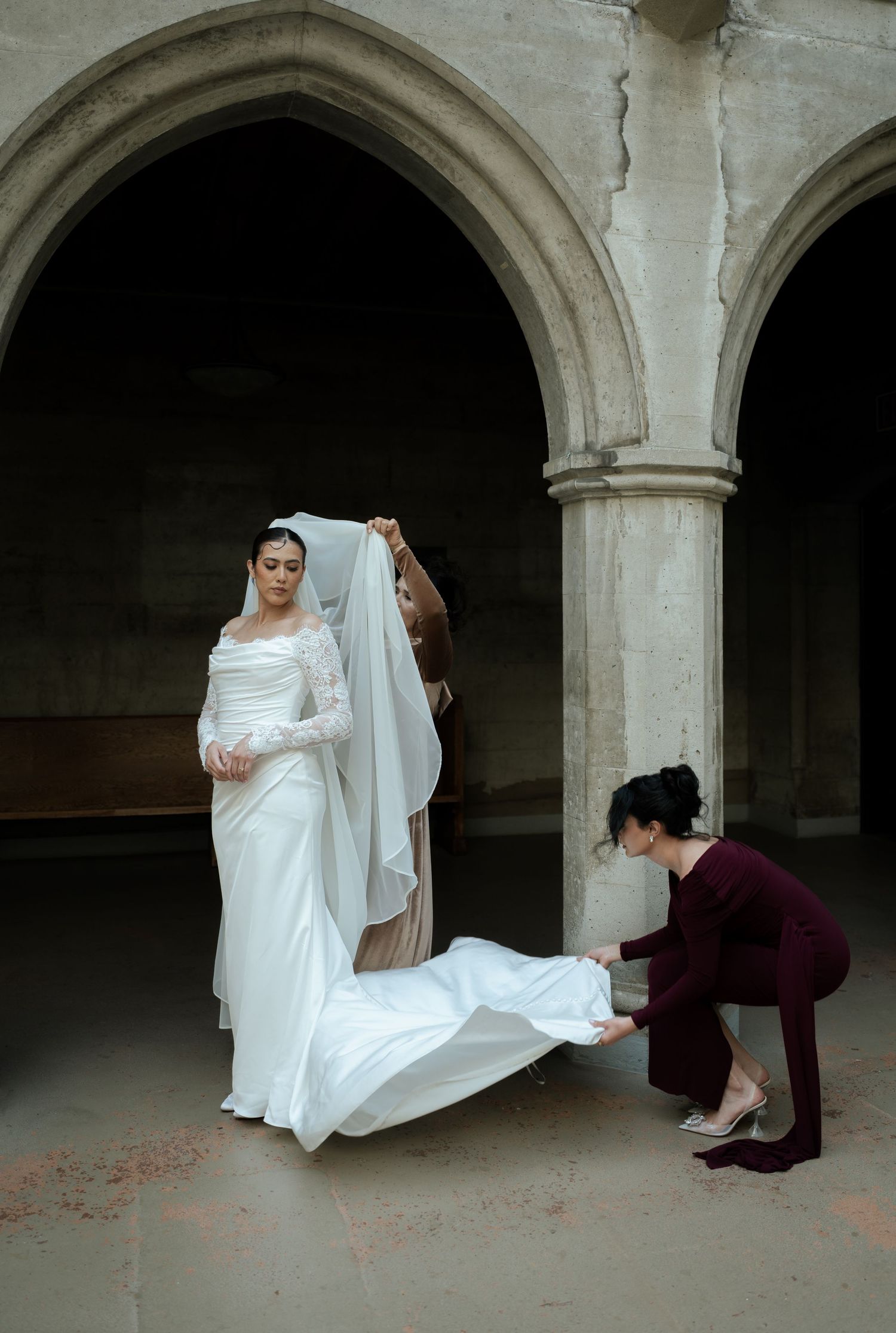 A series of artistic wedding photos showing flowing white dress movement against stone archways.