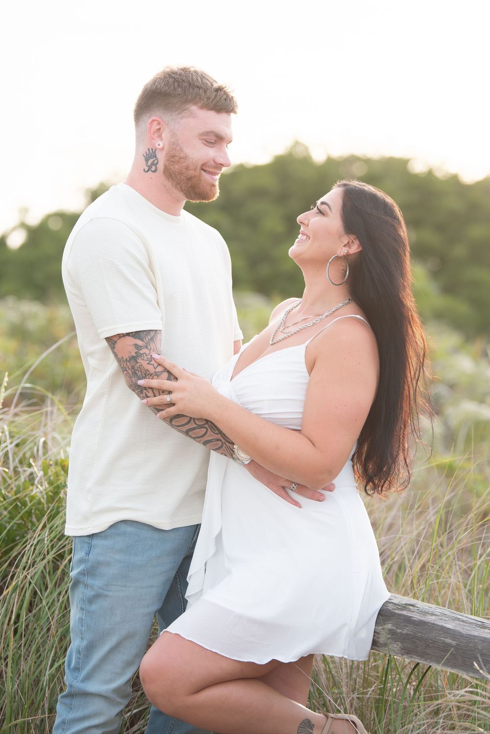 Couple sharing a joyful moment together on beach path at sunset.