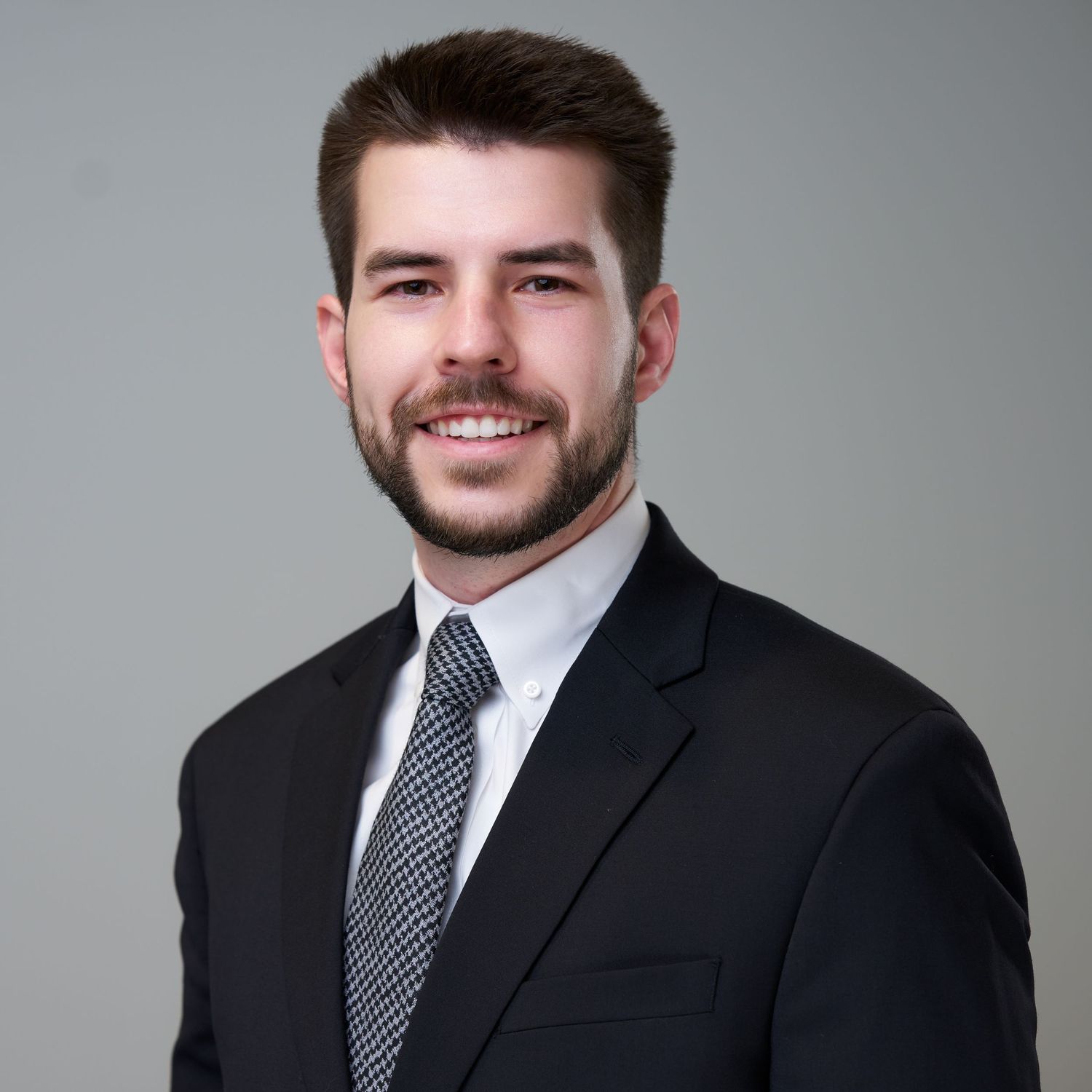 Professional portraits of person in dark suit with striped tie.