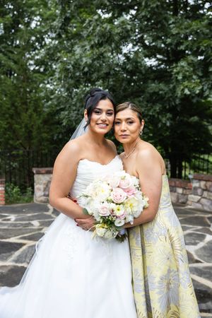 Two people in formal attire embracing on a stone patio during a wedding celebration. New Jersey wedding photographer