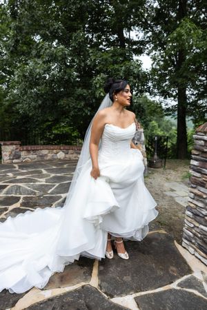 Flowing white wedding dress movement captured on stone patio with dramatic angles and natural lighting. New Jersey wedding photographer