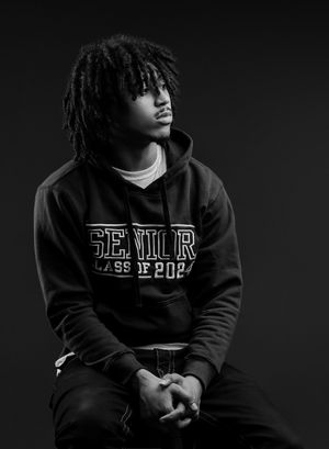 Artistic black and white portrait series showing a person in a dark hoodie against a dark background.