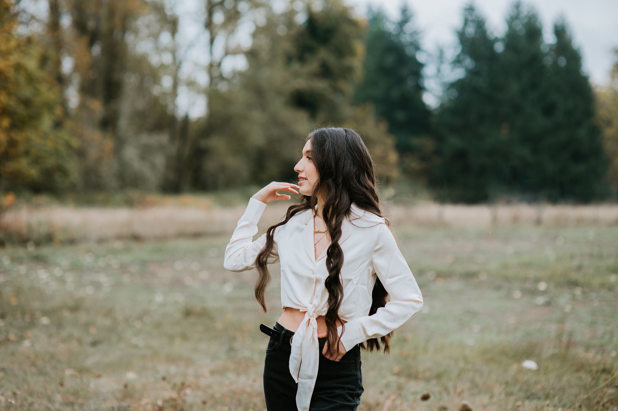 Casual outdoor autumn portrait with long braided hair and white button-down shirt.