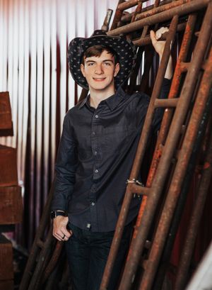 A stylish portrait in front of rusty scaffolding and corrugated metal wall.