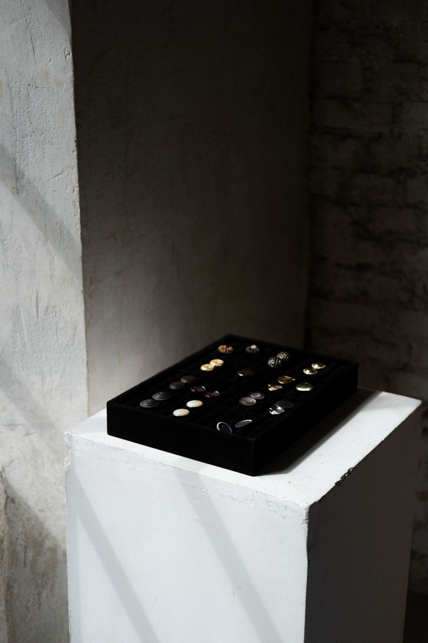 Artistic composition showing a black surface with small glowing lights casting dramatic shadows against white walls.