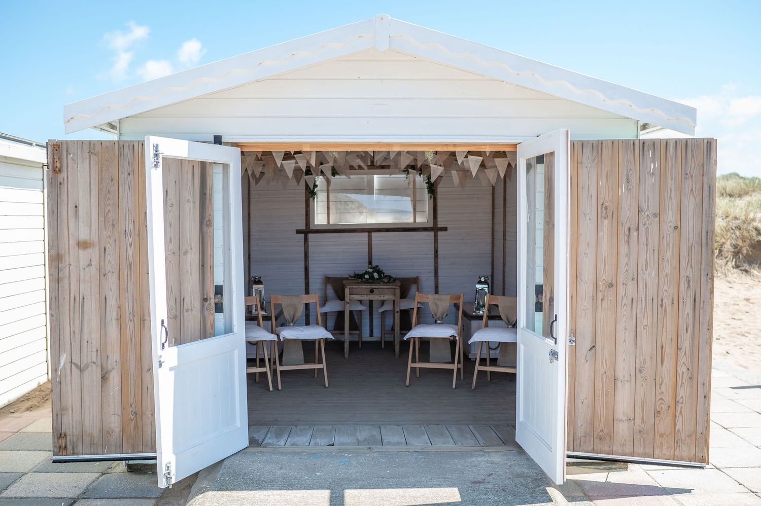 Inside of beach hut on Summerleaze beach in Bude. Set up for wedding ceremony with hessian decoration.