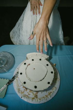 Hands arranging pieces on a white decorative plate to create a smiley face design.