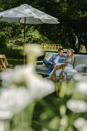 Outdoor wedding lounge area with white umbrellas and comfortable seating.