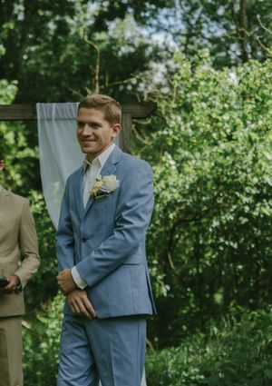 Wedding ceremony scene in a lush green garden setting.